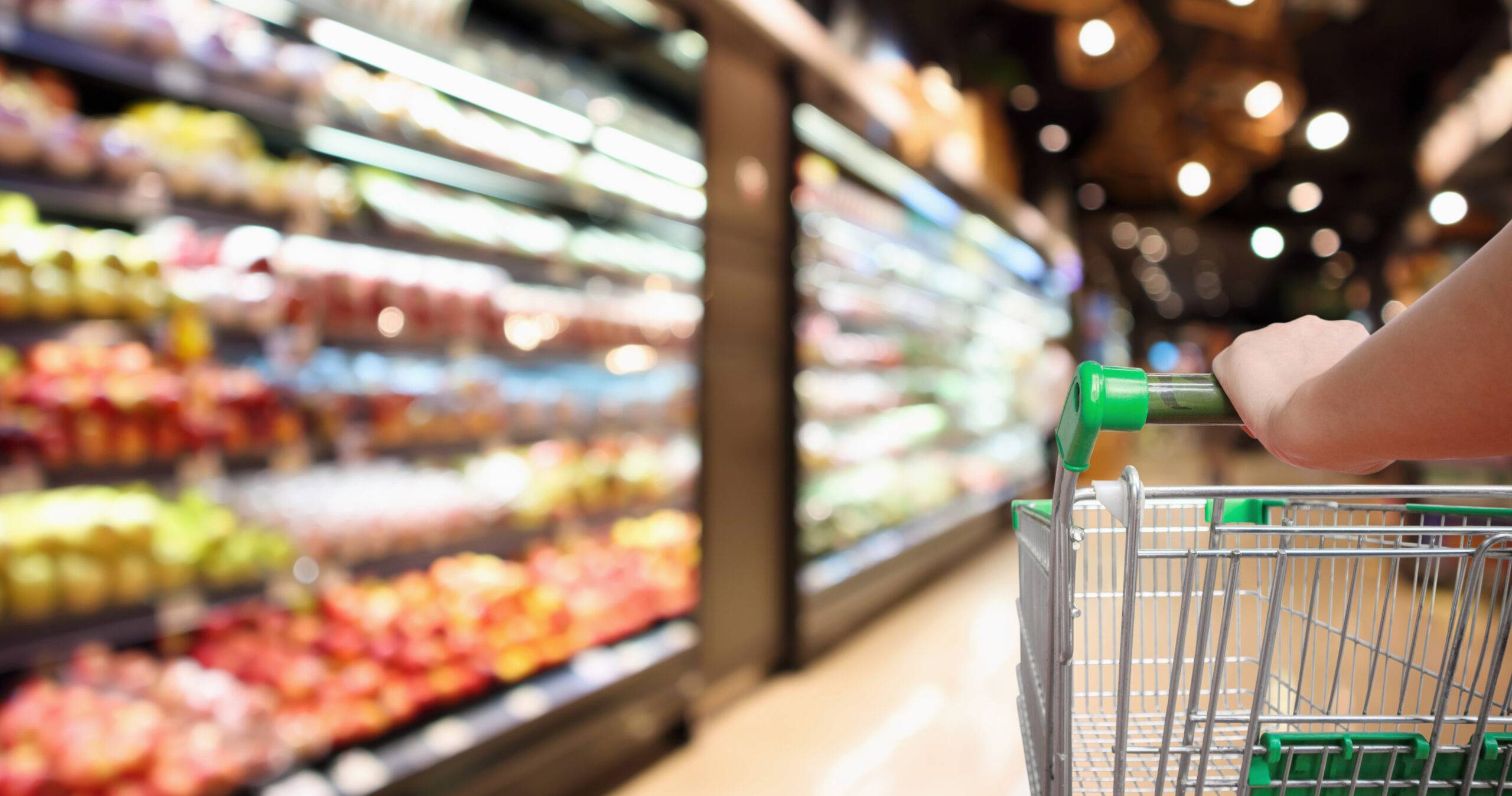 Shopping cart in a grocery store aisle, representing household logistics and personal errand management.